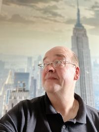 Portrait of man wearing sunglasses against buildings in city