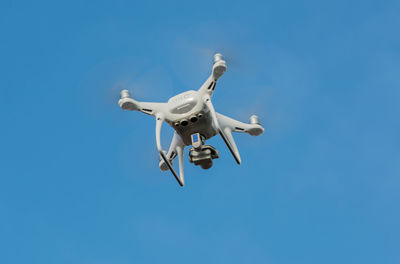 Low angle view of airplane flying against clear blue sky