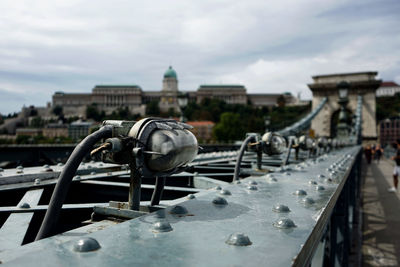 View of bridge in city against cloudy sky