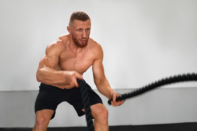 Full length of shirtless man looking at camera