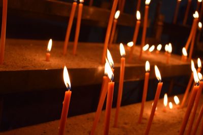 Close-up of illuminated candles on altar at church