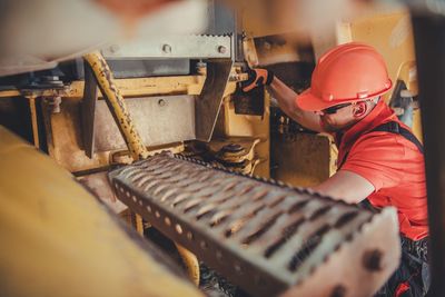 Side view of man working on machinery