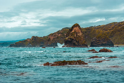 Scenic view of rocks in sea against sky