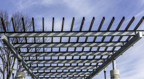 Low angle view of bridge against cloudy sky