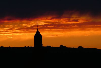 Silhouette building against sky during sunset