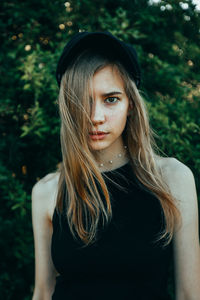 Young woman standing against trees