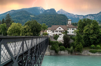 Building by river with mountain in background