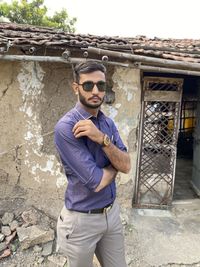 Portrait of young man wearing sunglasses standing outdoors