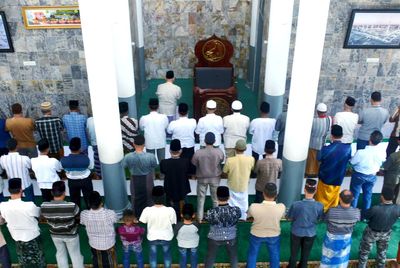 Rear view of people standing outside temple