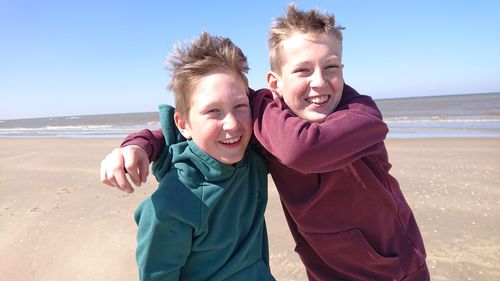 Portrait of happy boy on beach against sky