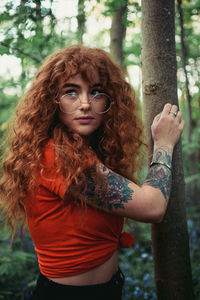 Portrait of young woman in tree trunk