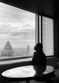 Man looking through window in city