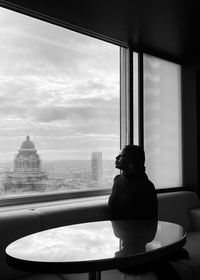 Man looking through window in city