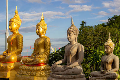 Statues at temple against sky