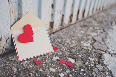 Heart shape paper and letter against wall