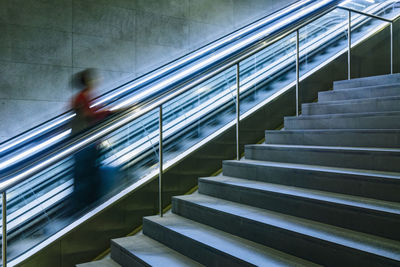 Blurred motion of man walking on escalator