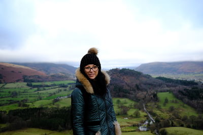 Portrait of woman standing against landscape during winter