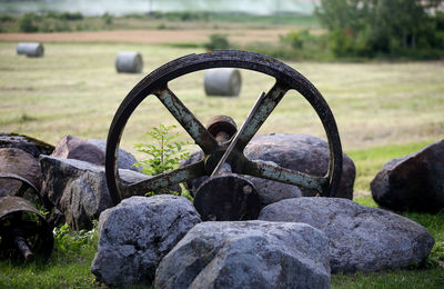 Close-up of rusty wheel on field