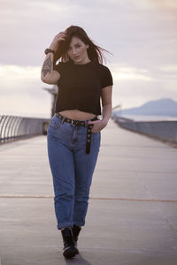 Portrait of beautiful woman standing against sky