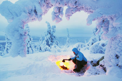 Woman having campfire at winter