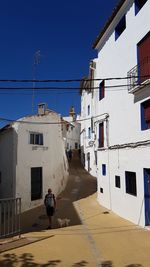 Rear view of man and buildings against sky