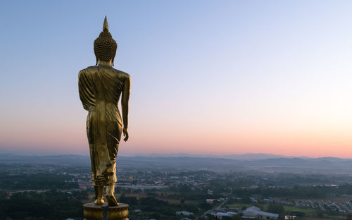 Big golden buddha statue standing in wat phra that kao noi on morning at nan province thailand,