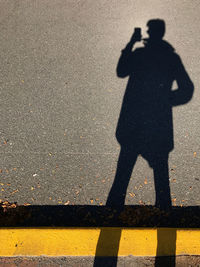 Shadow of man on road