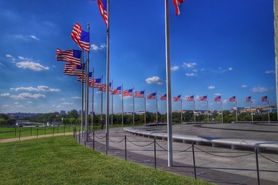 American flags in park against sky
