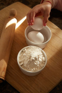 Cropped hands of a child preparing food on table