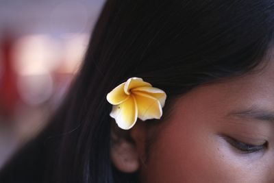 Close-up of young woman with flower