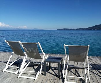 Three deckchairs by the sea