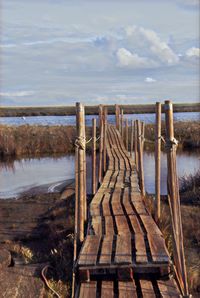 Wooden posts on beach against sky