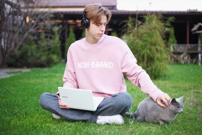 Man using mobile phone while sitting on grass