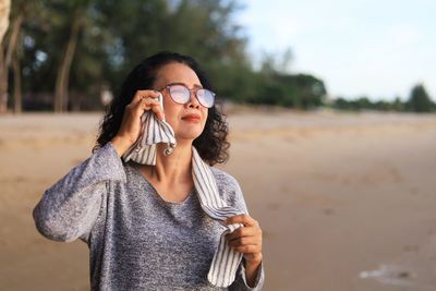 Portrait of beautiful young woman standing on land