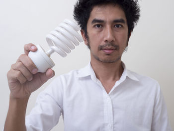 Portrait of young man standing against white background