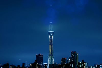 Low angle view of illuminated tower against blue sky