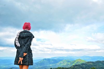 Rear view of woman looking at mountain range against sky