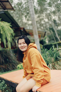 Portrait of young woman sitting on table