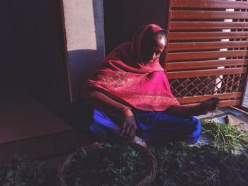 High angle view of woman sitting on chair at home