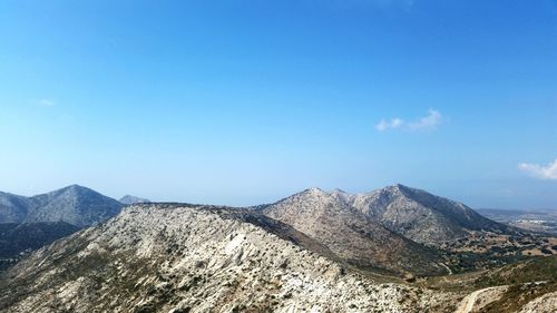 Scenic view of mountains against blue sky