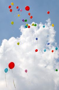 Blue sky and white clouds with large colorful balloons inflated with helium gas 