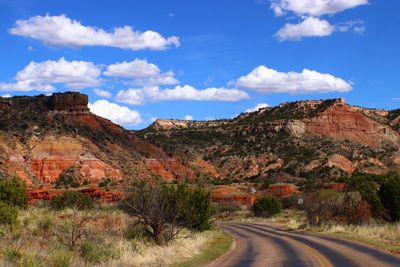 Road by mountain against sky