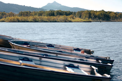 Boats moored in lake against sky