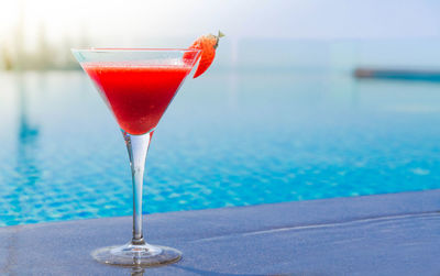 Close-up of red wine in glass at swimming pool