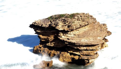 Stack of rock in sea against sky