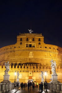 Statue in city at night