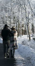 Rear view of people walking on road in winter