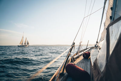 A schooner in maine bay viewed from another sailboat during late day