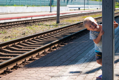 Full length of boy standing on railroad station platform
