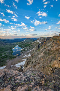 Scenic view of landscape against cloudy sky during sunset